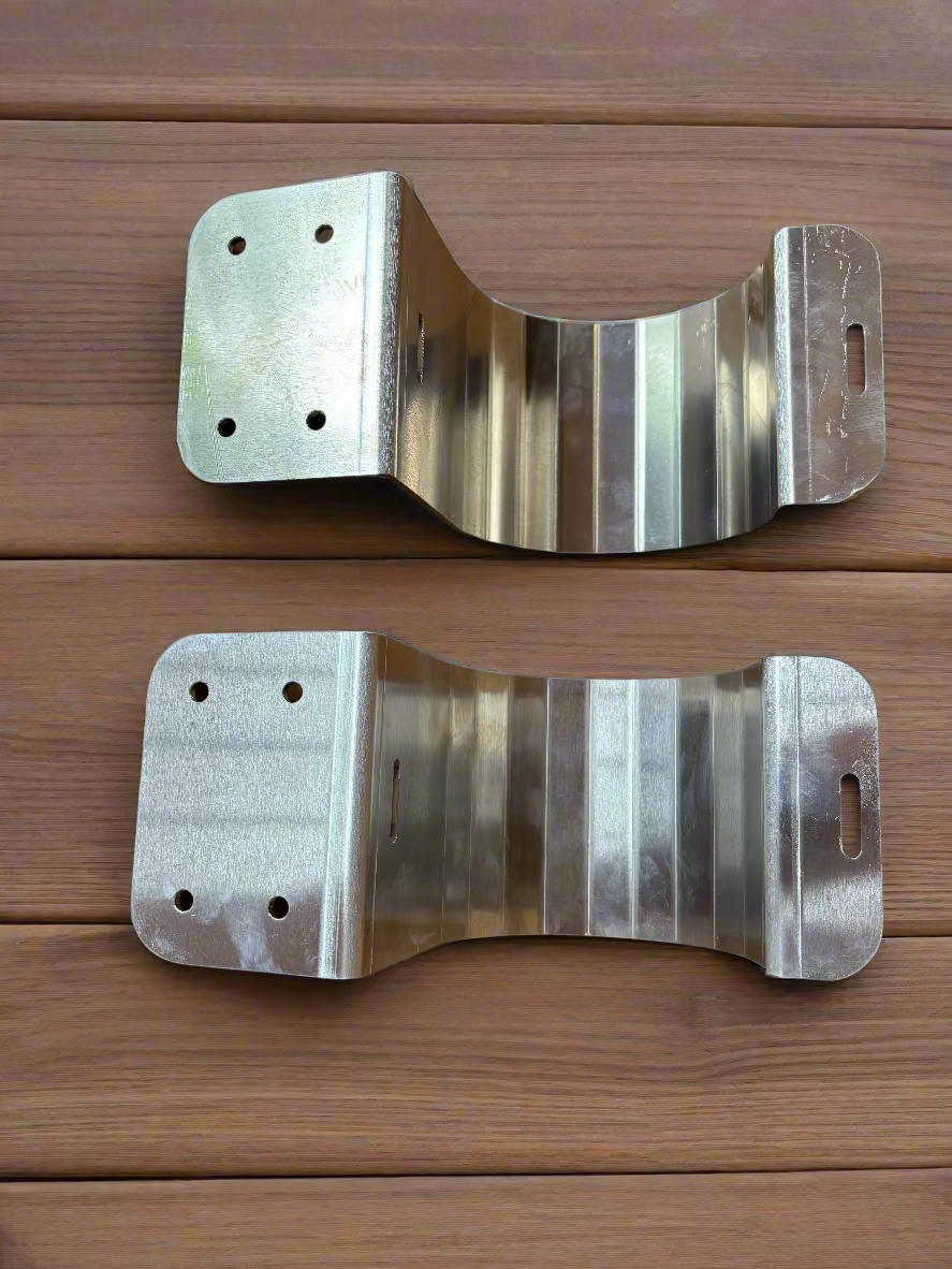 Two metallic brackets on a wood deck