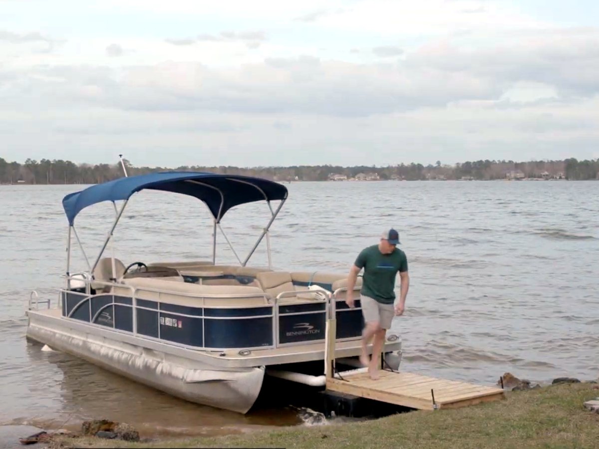 Boater stepping off onto the dock while Docked holds his pontoon in place